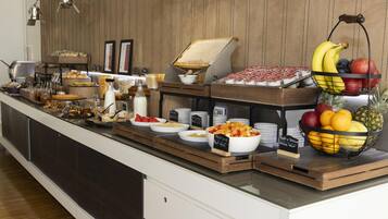Un buffet con diversi piatti e un'esposizione di frutta.