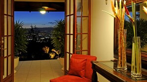 An open door leading to a balcony with a city view at dusk. - Ringle Resort & Spa (Escazu)