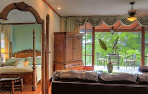 Une chambre à coucher avec un lit à baldaquin, une armoire en bois et un canapé.
