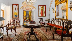 A room with a round table, chairs, a chandelier, and ornate decorations. - Ayenda Meson de San Sebastian (Puebla)