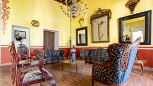 A room with ornate furniture, a chandelier, and a large mirror. - Ayenda Meson de San Sebastian (Puebla)