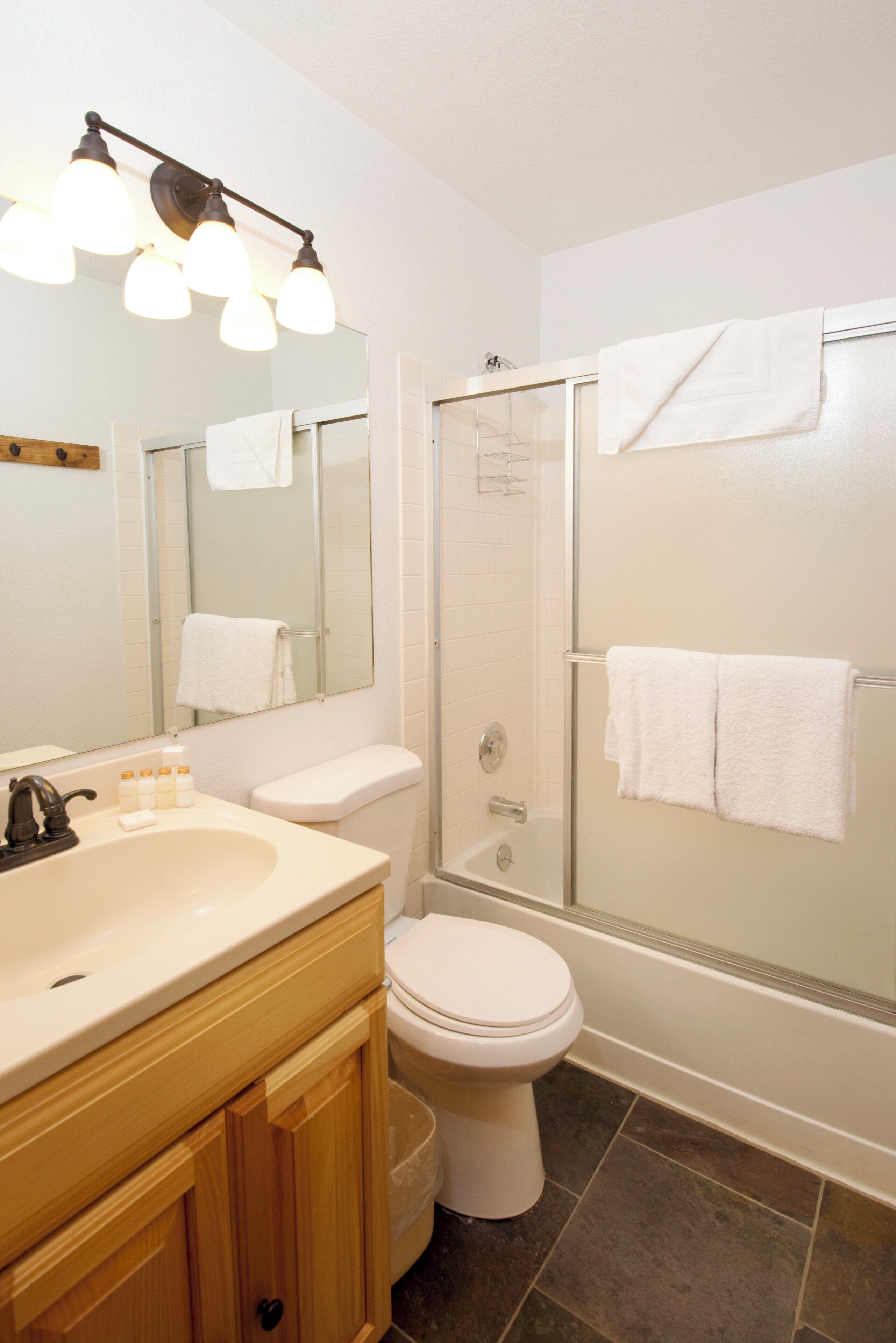 A bathroom with a sink, toilet, and shower.