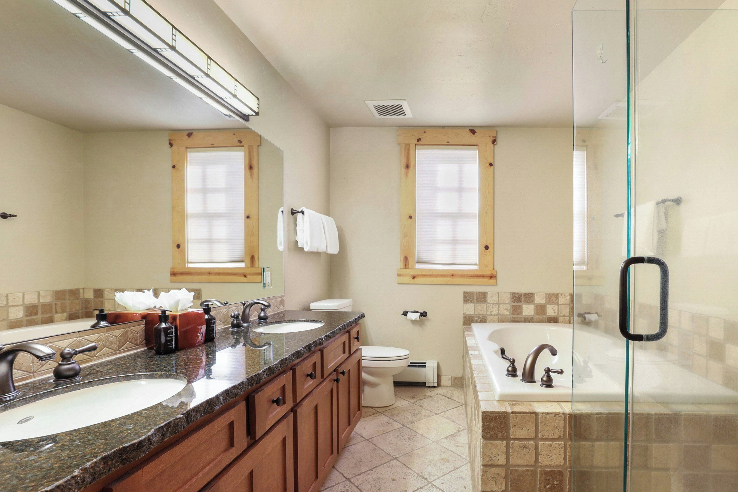 A bathroom with two sinks, a toilet, and a bathtub.