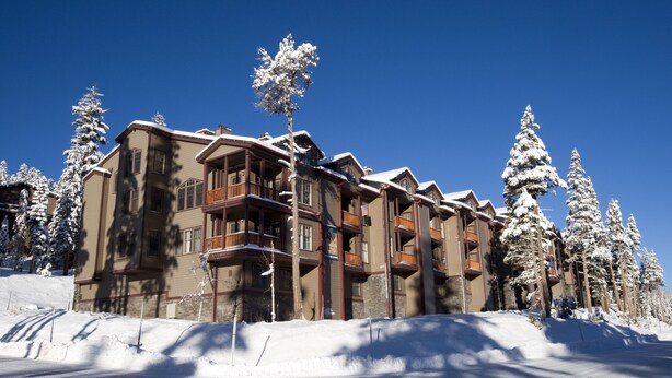 A multi-story hotel with balconies, surrounded by snow-covered trees. - Kirkwood Mountain Resort by Vail Resorts (Kirkwood)