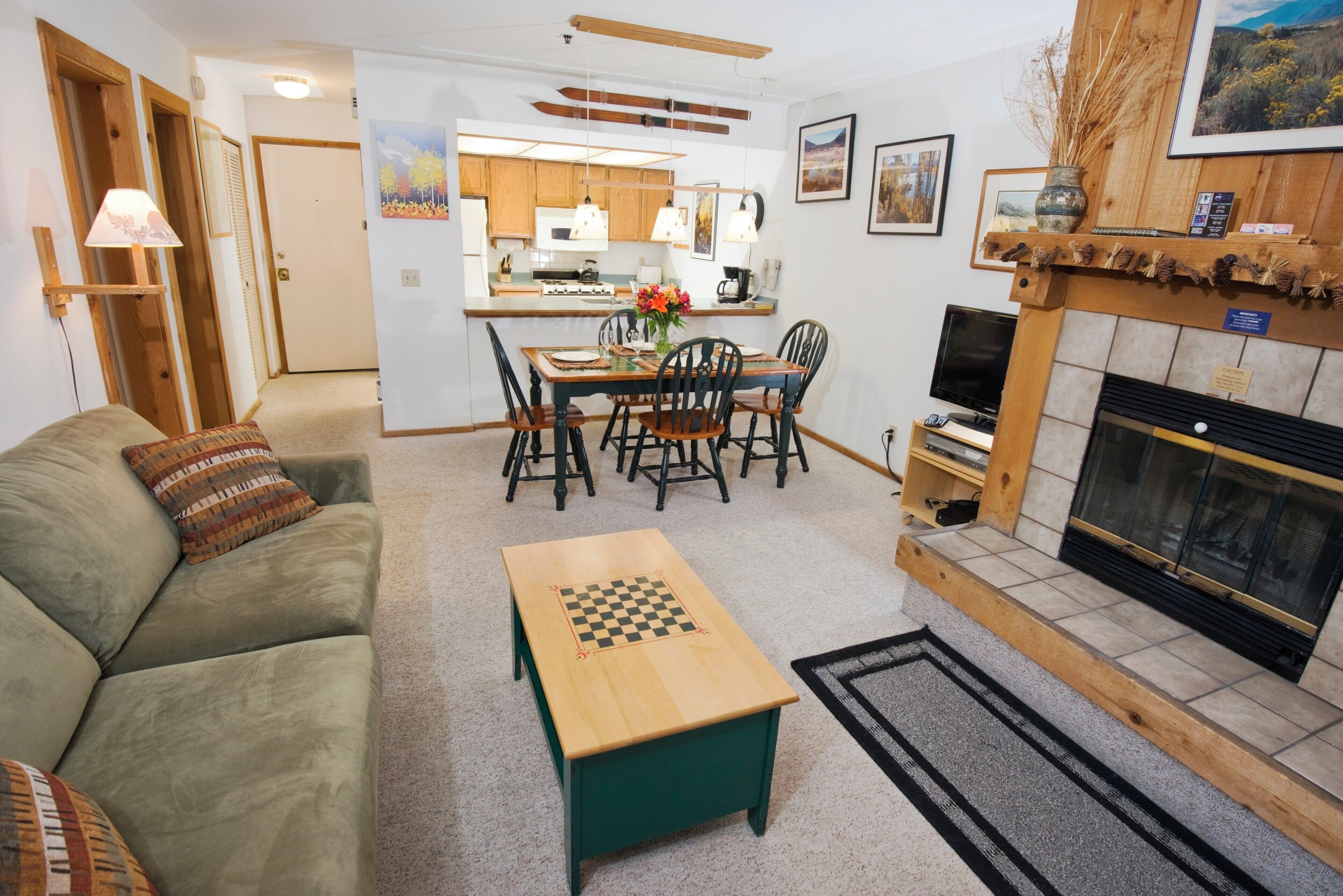 A living room with a green sofa, a wooden coffee table, and a fireplace.