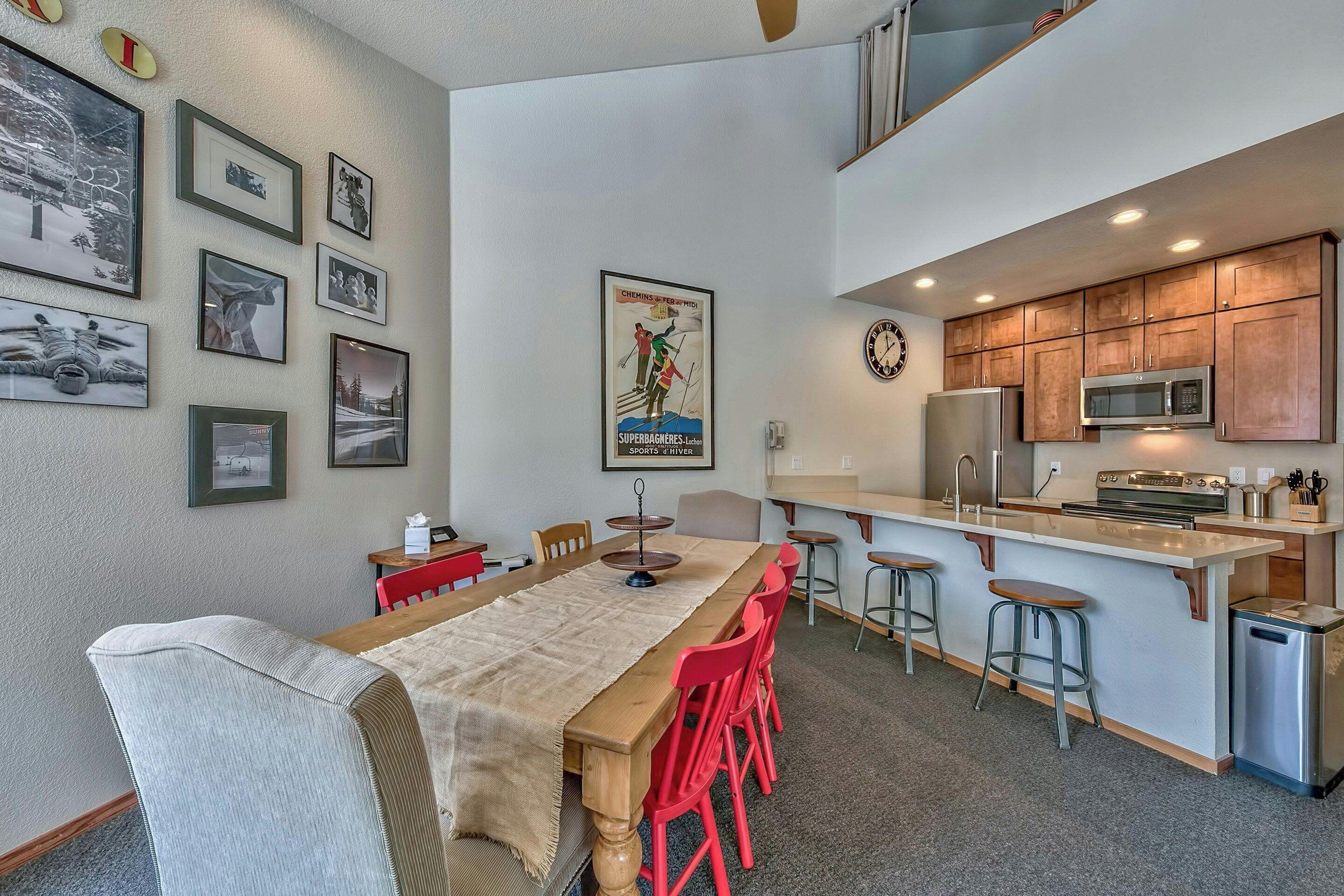 A modern kitchen with wooden cabinets, a stainless steel refrigerator, and a microwave.