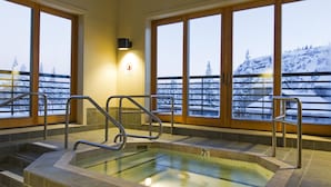A hot tub with a view of a snowy landscape through large windows. - Kirkwood Mountain Resort by Vail Resorts (Kirkwood)