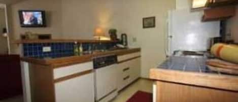 A compact kitchen with a small island, a microwave, and a sink.