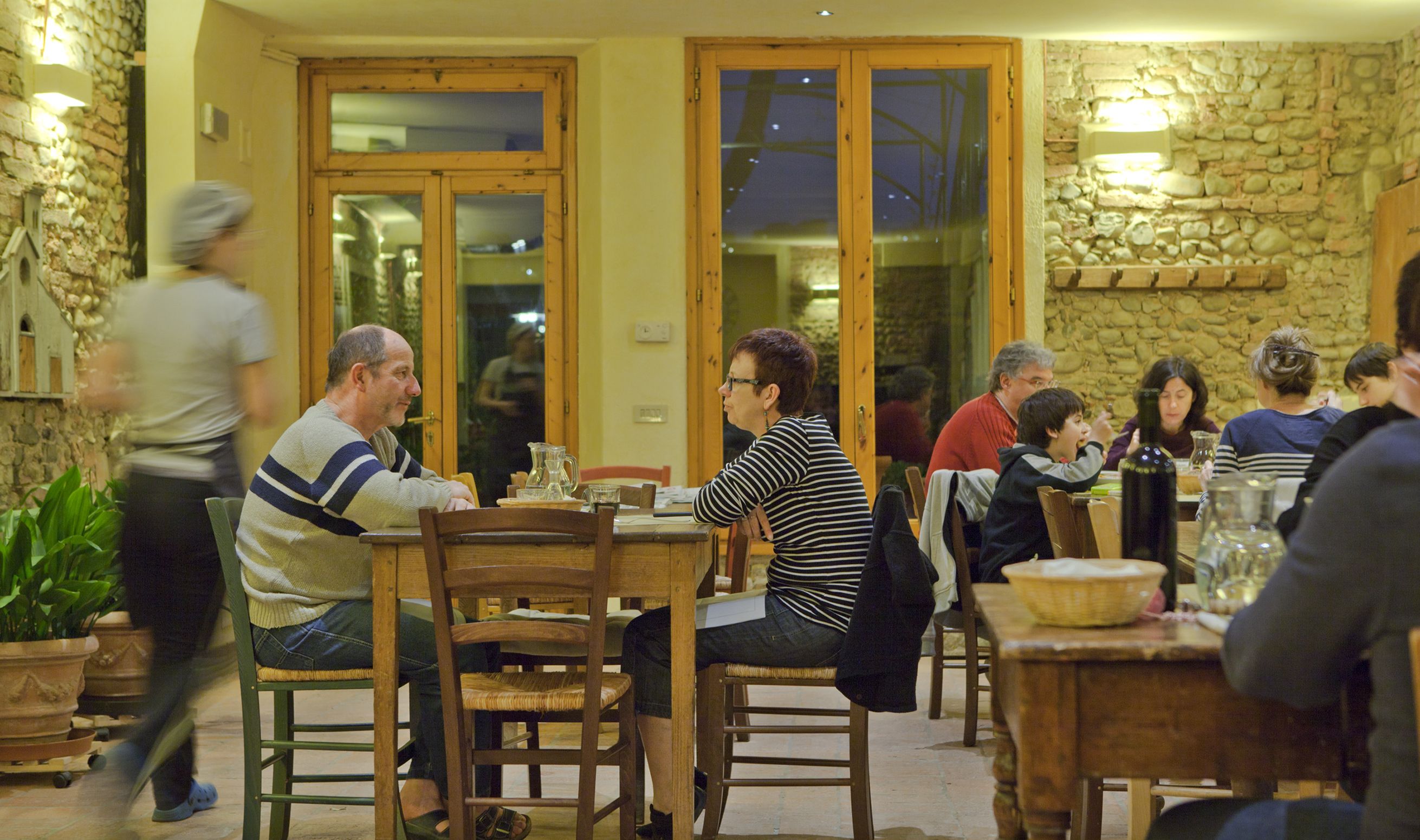 A restaurant with wooden furniture and stone walls.