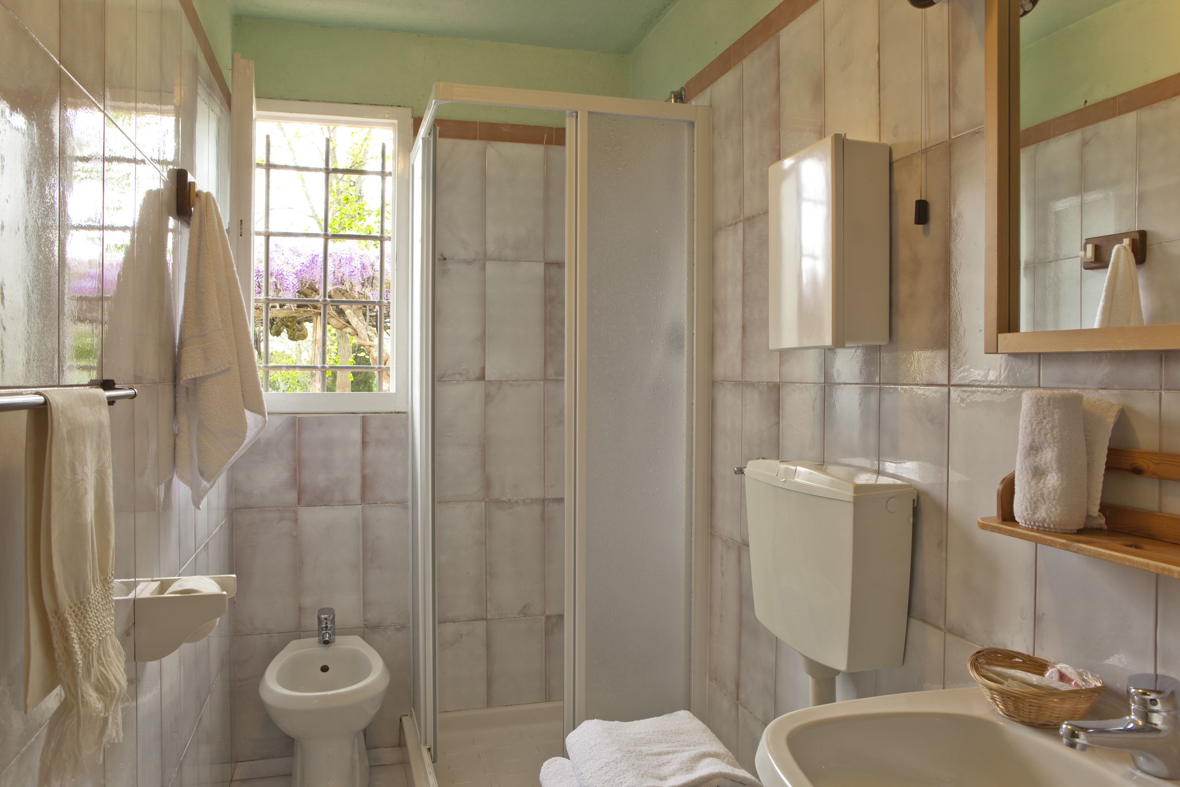 Un bagno con doccia, bidet e due lavandini.