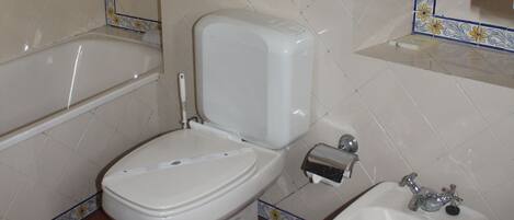 Une salle de bain comprenant des toilettes, un bidet et un lavabo.