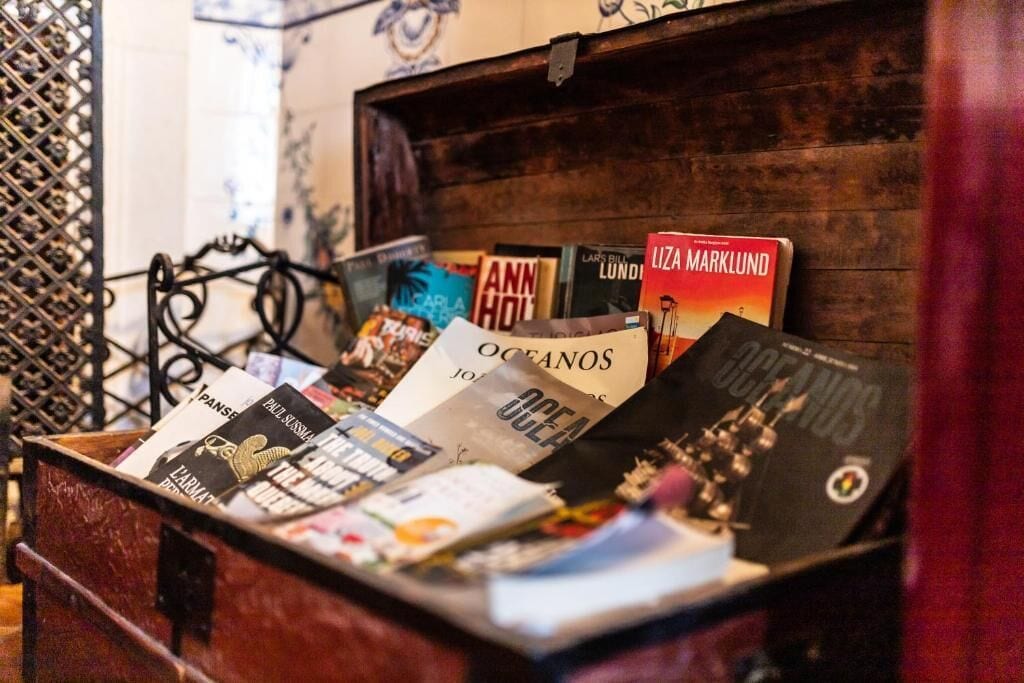A wooden chest filled with various books, including titles like 'Oceans' and 'Liza Marklund.'