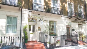 A hotel with a white facade, black iron railings, and a sign that reads "BALMORAL HOTEL". - Balmoral House Hotel (London)