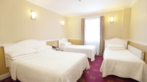 A hotel room with two single beds, a small table, and a chair. - Balmoral House Hotel (London)