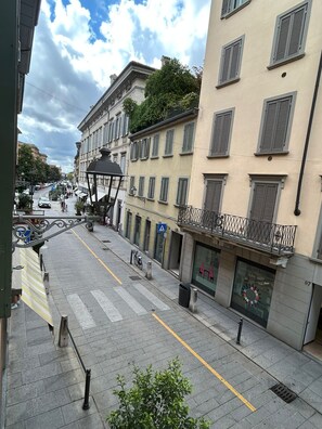 A street view with buildings, a pedestrian crossing, and a bicycle parked on the sidewalk. - La Castellana (Bergamo)