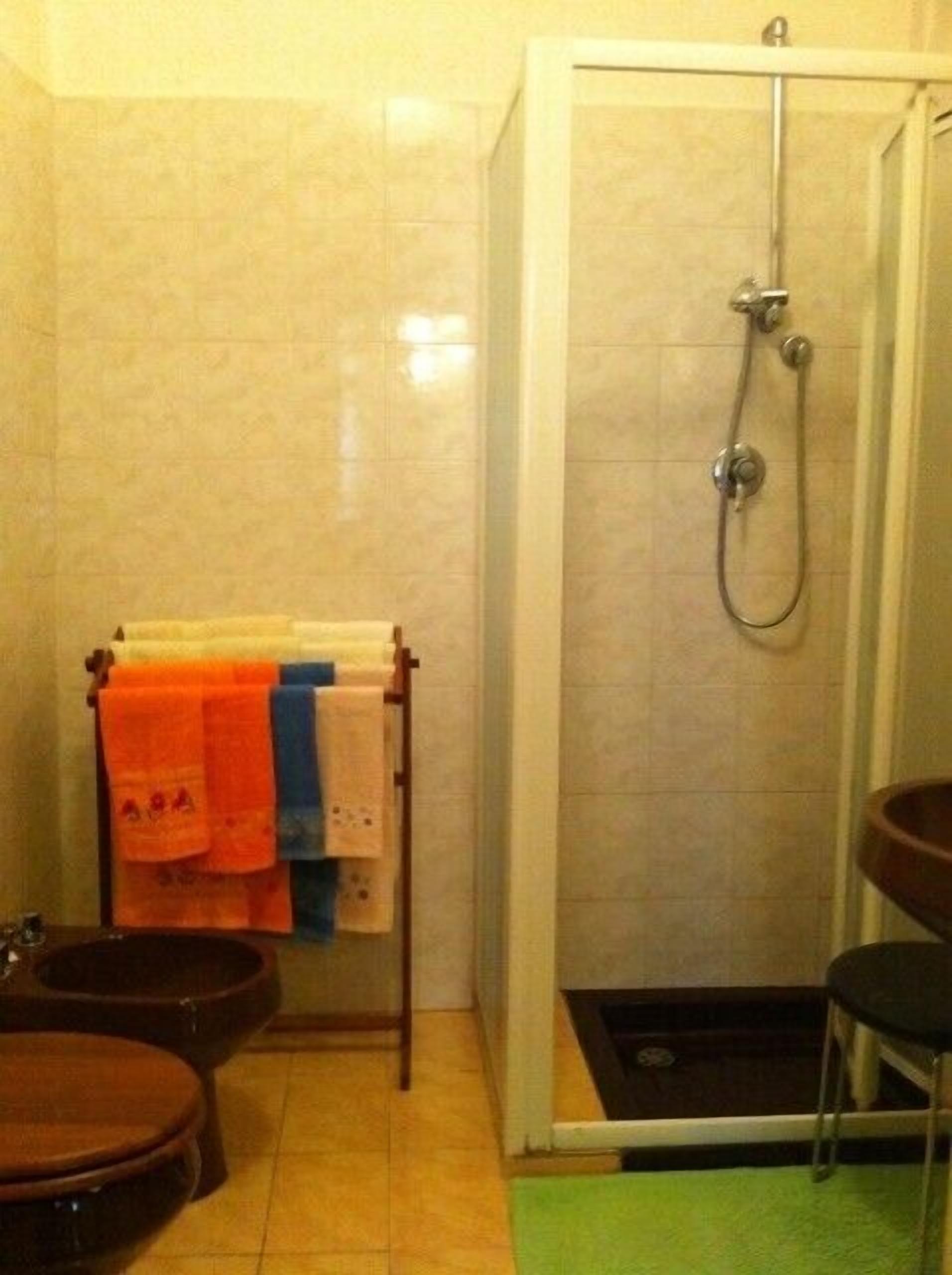 Une salle de bain avec douche, toilettes et lavabo.