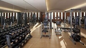A gym with various exercise equipment, including dumbbells, treadmills, and weight machines. - Al Jasra Boutique Hotel (Doha)