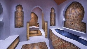 A room with a central seating area, arched alcoves, and patterned wall designs. - Al Jasra Boutique Hotel (Doha)