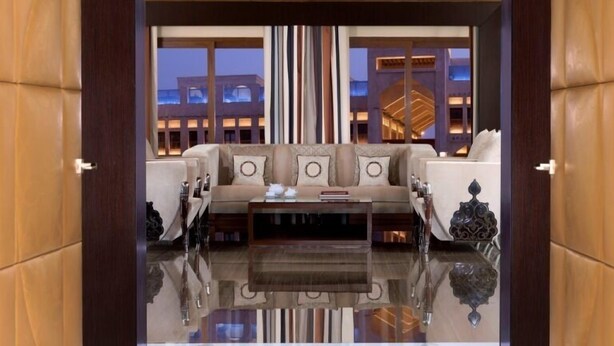 A modern living room with a sofa set, a coffee table, and a patterned rug. - Al Jasra Boutique Hotel (Doha)