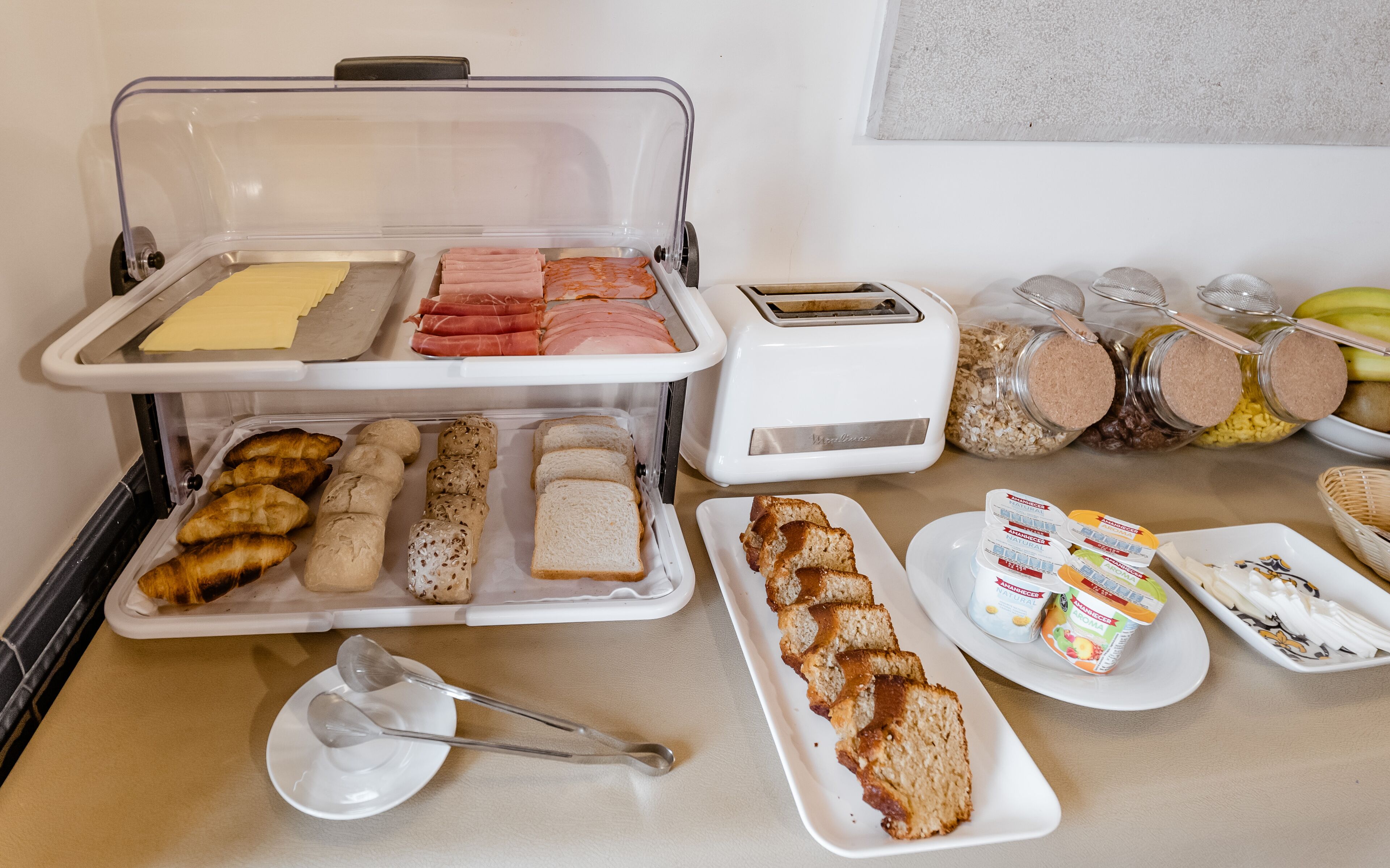 A buffet with various food items including bread, pastries, and spreads.