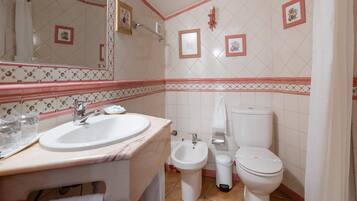Une salle de bain équipée d’un lavabo, d’un bidet et de toilettes.