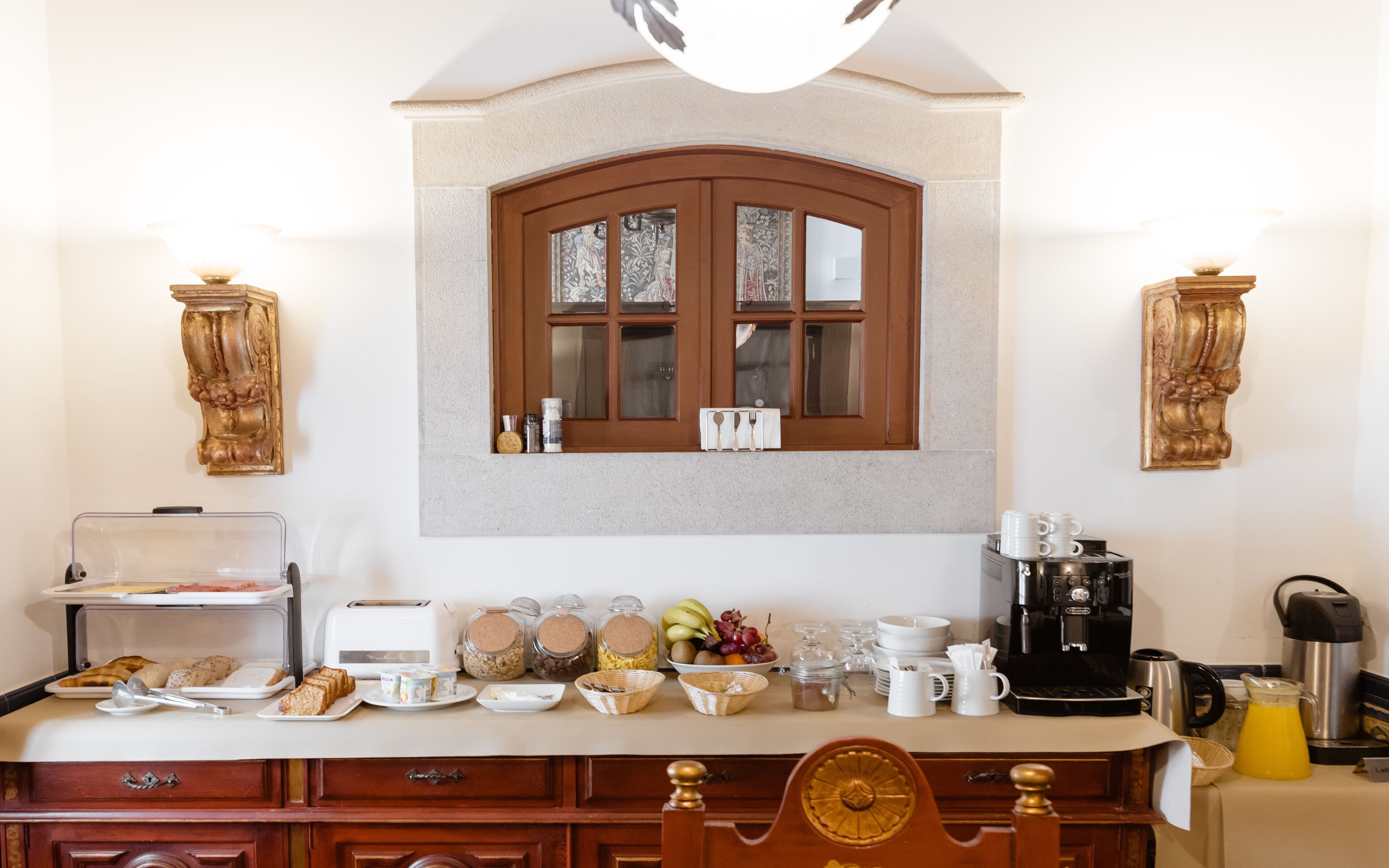 A kitchen with a wooden cabinet, a window, and various kitchen appliances and utensils.