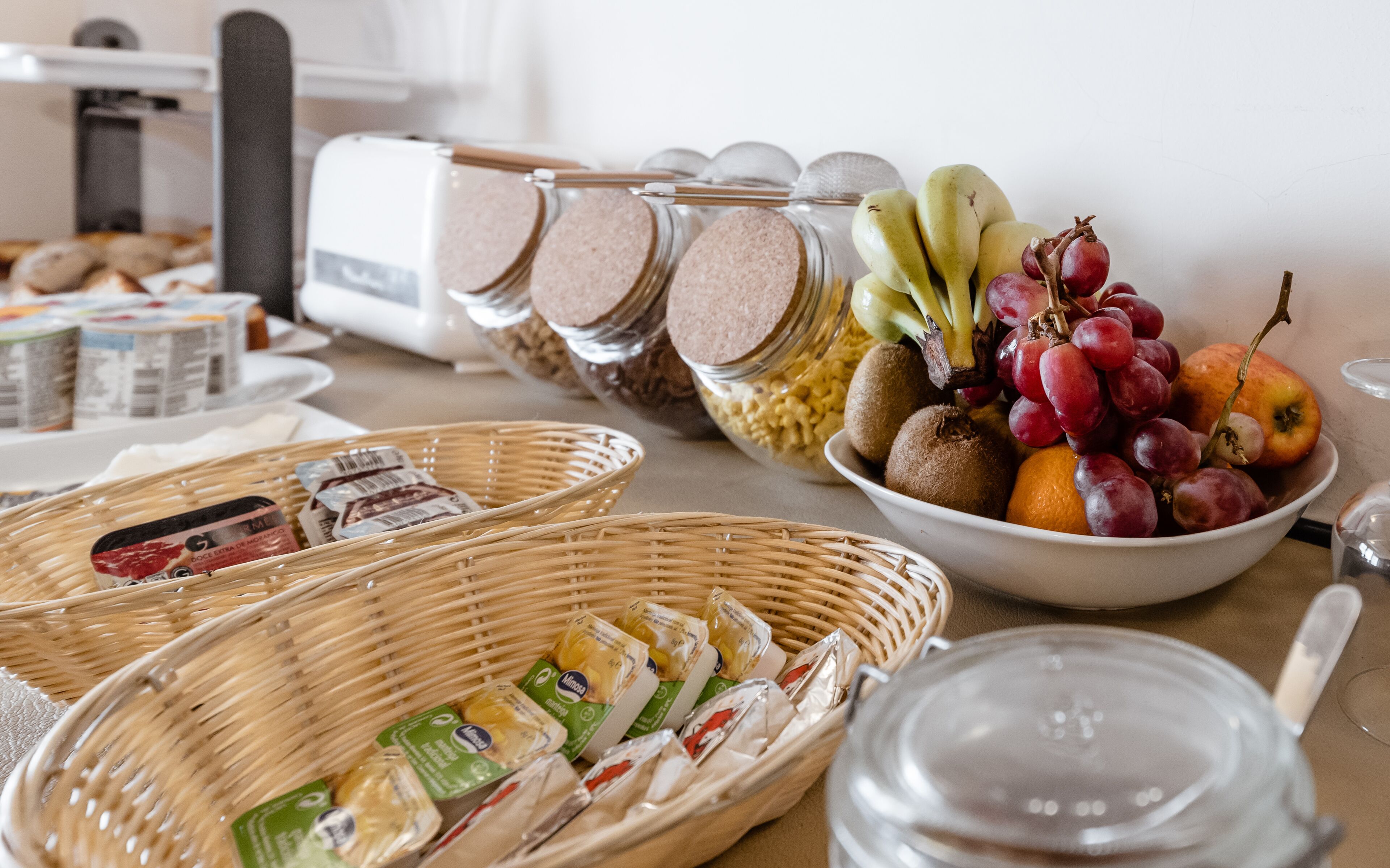 Un bufé de desayuno con diversos alimentos, como frutas, pan y productos envasados.