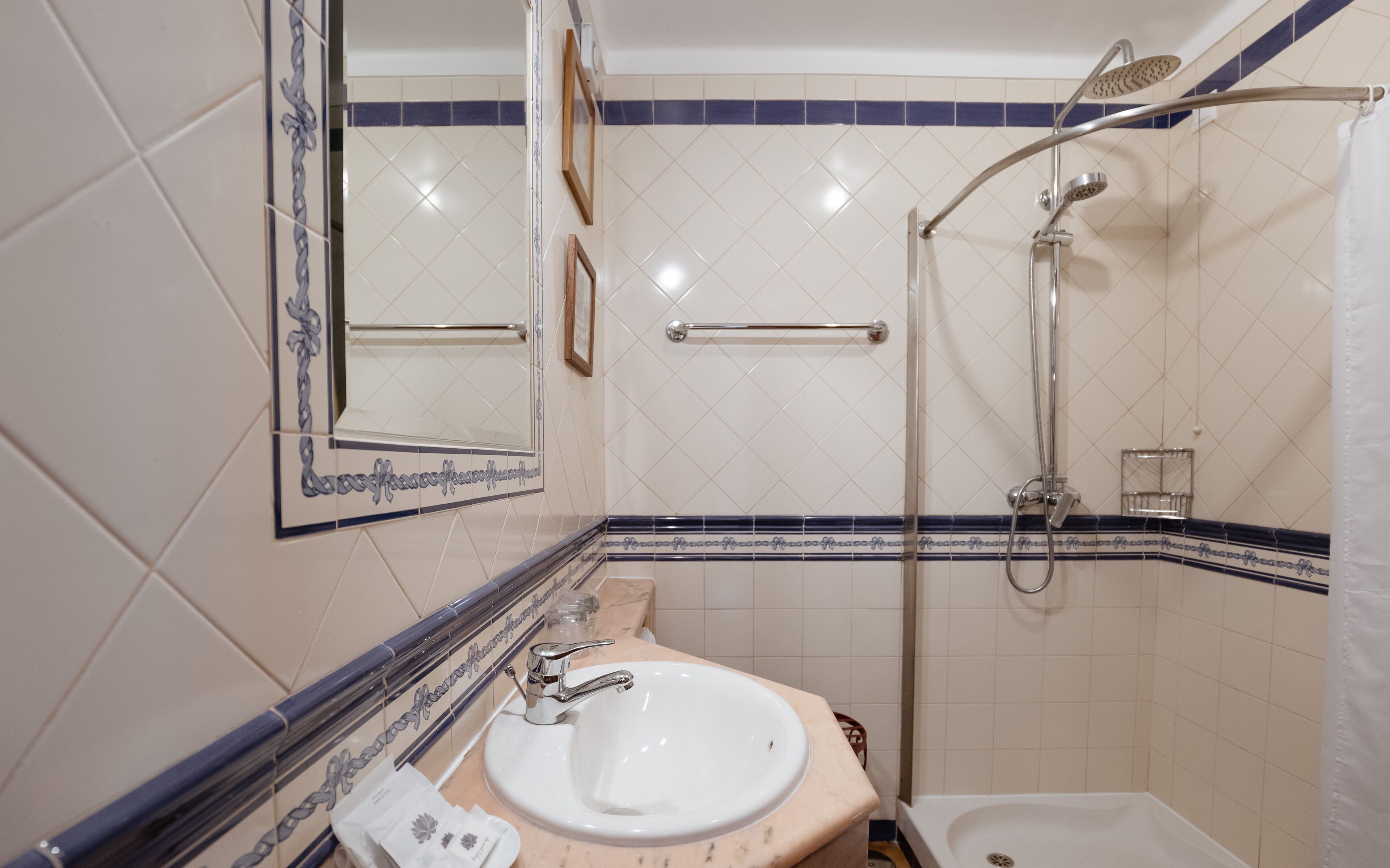 Baño con lavamanos, espejo y ducha.