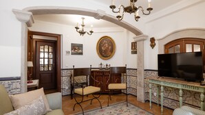 A living room with a TV, a fireplace, and a chandelier. - Casa de Sao Thiago d' Obidos (Obidos)