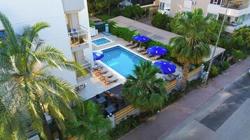 Una piscina al aire libre de temporada, sombrillas