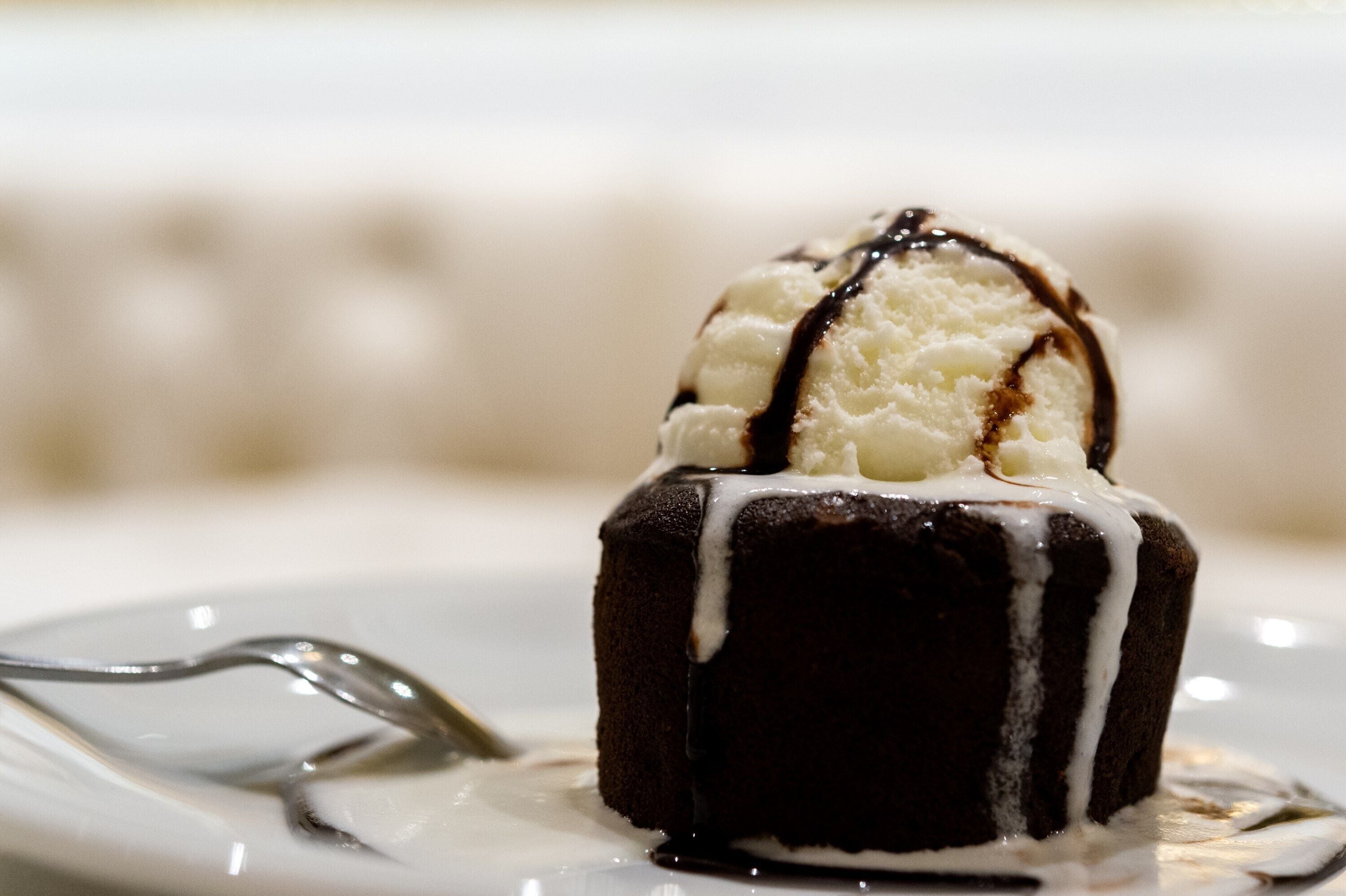 A dessert with a scoop of ice cream on top, drizzled with chocolate sauce.