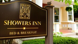 Un letrero de Showers Inn con un símbolo de bed and breakfast, indicando que el establecimiento ofrece alojamiento y desayuno.