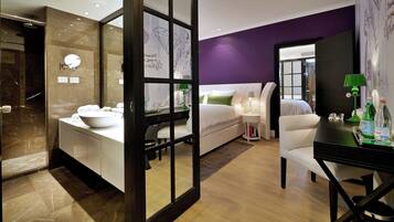 Een moderne hotelkamer met een badkamer, een bed, een bureau en een stoel.