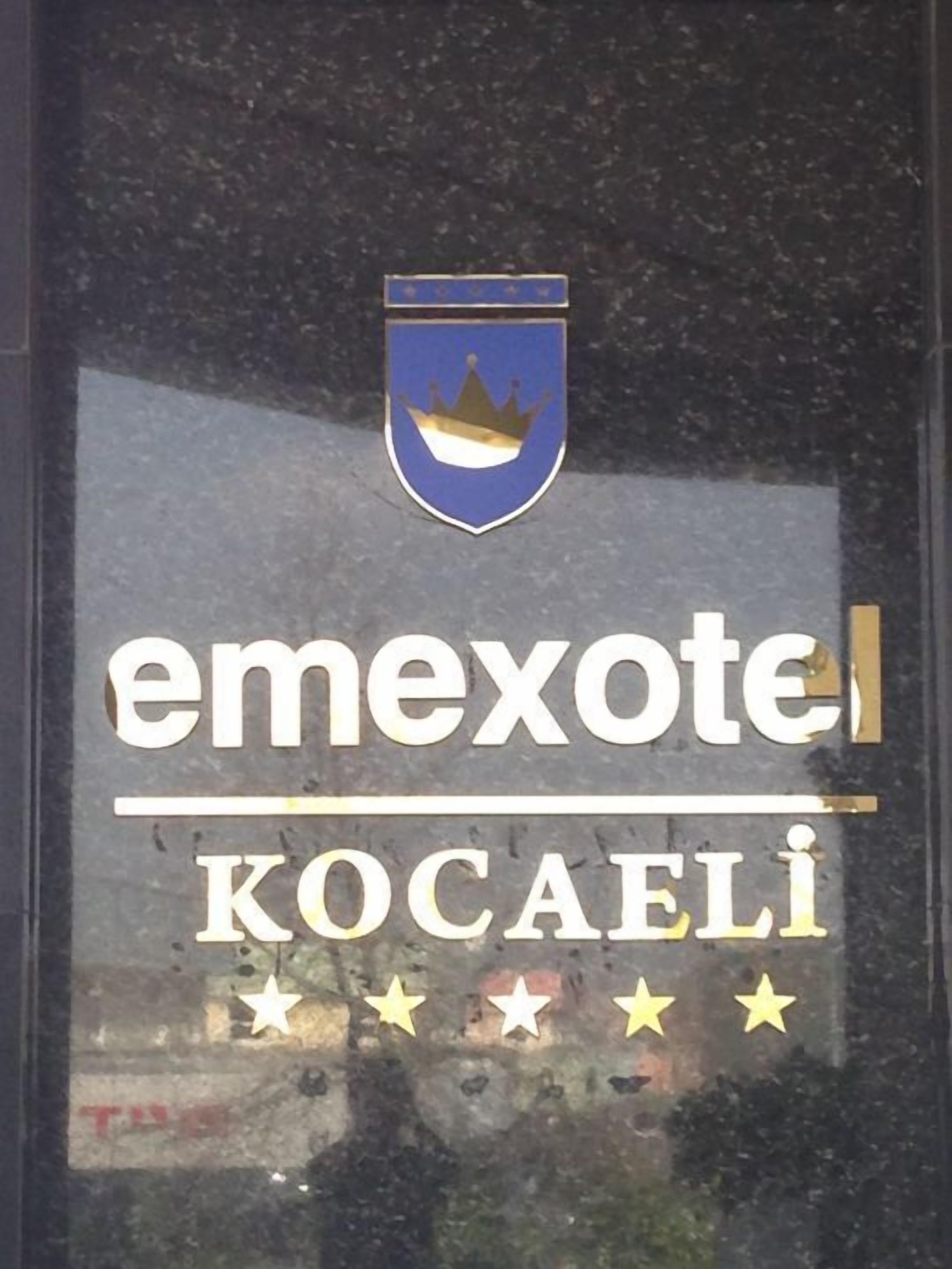 Un cartel de hotel con un emblema de corona y el nombre "emexotel Kocaeli".