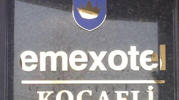 Un cartel de hotel con un emblema de corona y el nombre "emexotel Kocaeli".