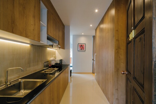 A modern kitchen with wooden cabinets, stainless steel appliances, and a black countertop.