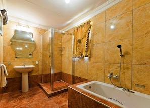 A bathroom with a glass-enclosed shower, a sink, and a bathtub. - Golden Gate Guest House (Sandton)