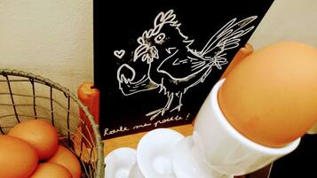 Una cesta de huevos, una tarjeta negra con un dibujo y texto, y un objeto de cerámica blanca.