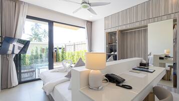 A modern hotel room with a bed, a desk with a lamp, a phone, and a large mirror.