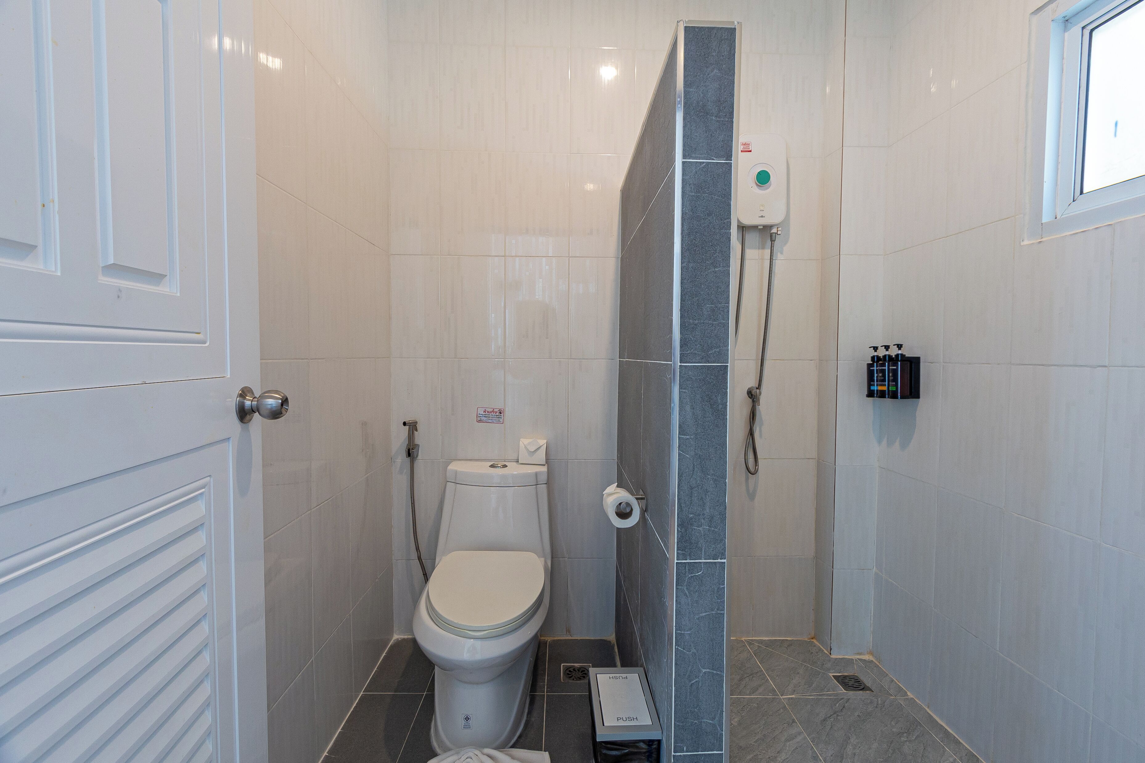 Ein Badezimmer mit Toilette, Dusche und einem Handtrockner.