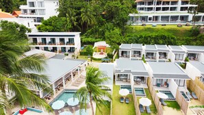 A resort with multiple bungalow-style accommodations, a central pool area, and lush greenery surrounding the property. - Three Trees Samui Resort - Sarocha Villa (Koh Samui)