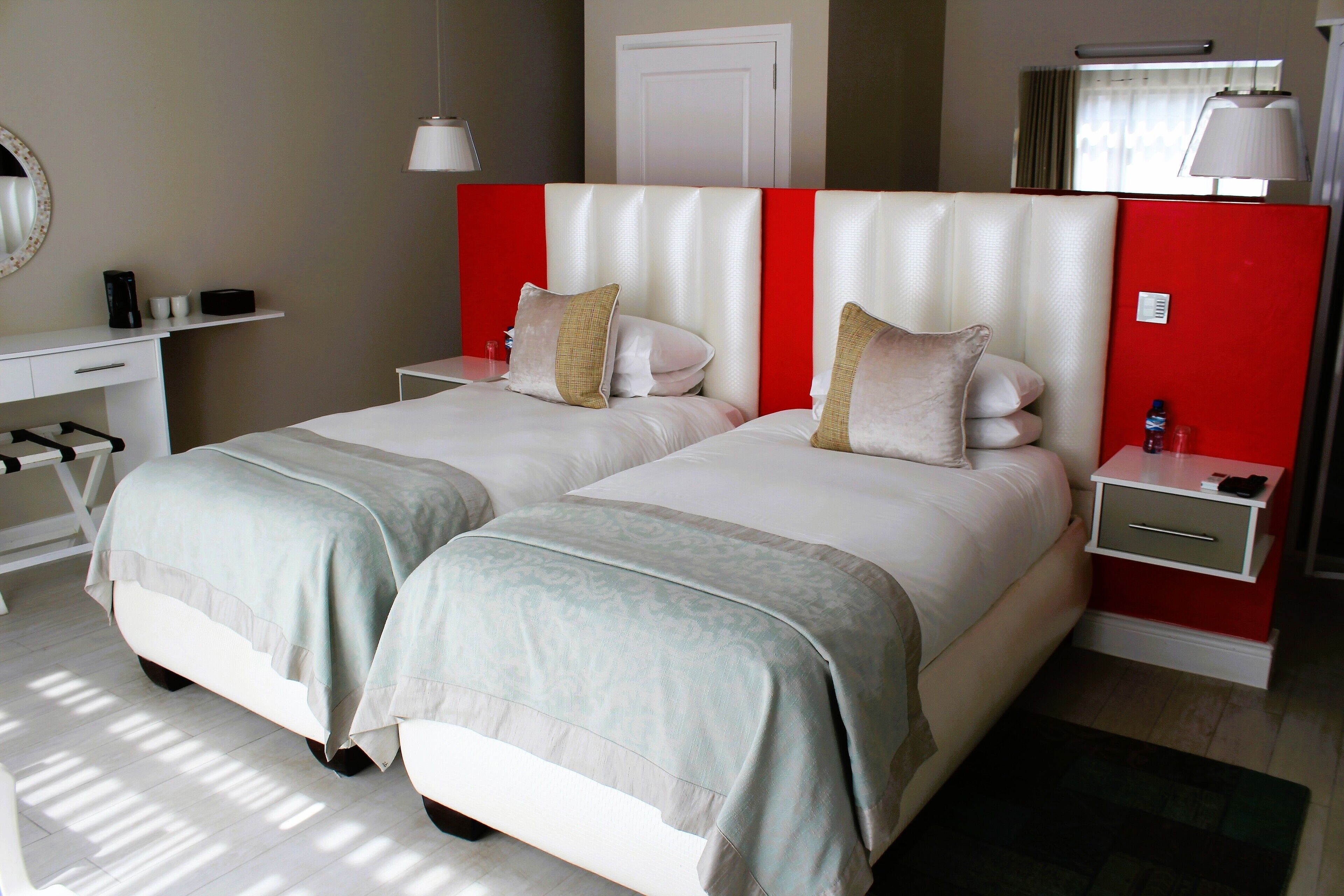A hotel room with two beds, a desk, and a nightstand.