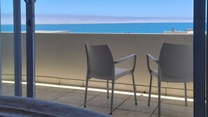 A balcony with a view of the ocean, two chairs, and a bed. - Atlantic Villa Boutique Guesthouse (Swakopmund)
