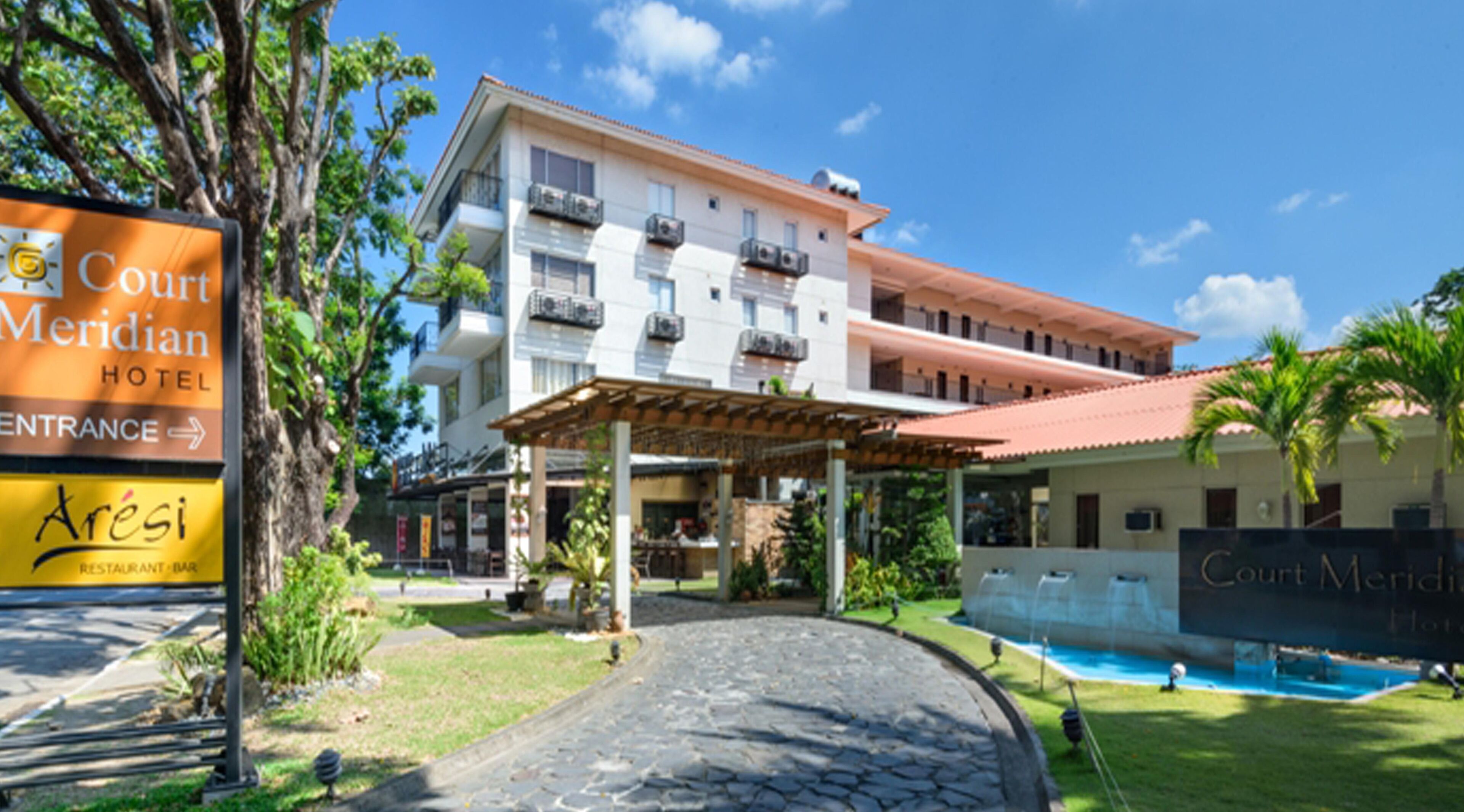 A hotel entrance with a sign for Court Meridian Hotel and a restaurant named Aresi.