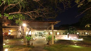 Entrada de hotel bem iluminada com varanda coberta, área de recepção e uma placa com a inscrição 'Court Marriott'.
