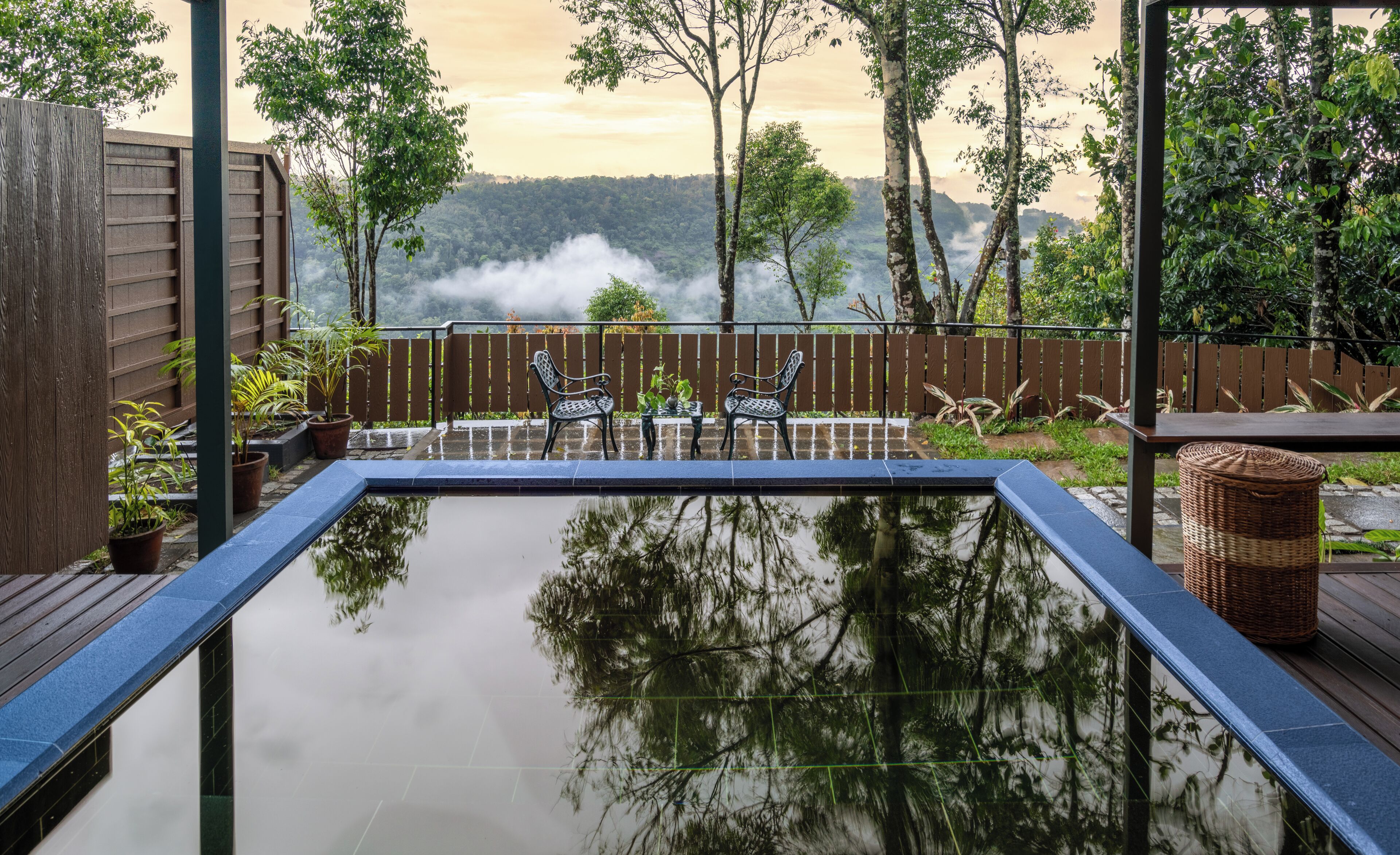 A serene indoor pool area with a view of a forested mountain range.