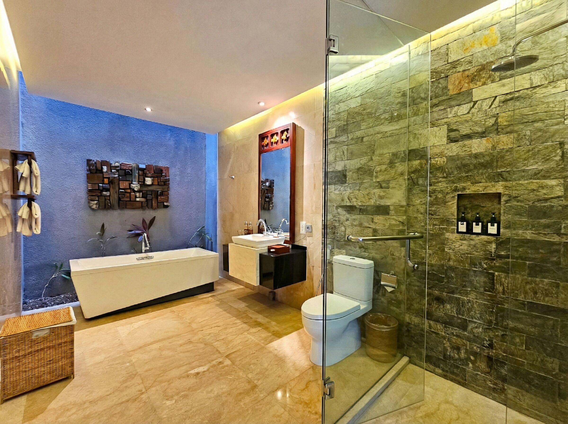 Un baño moderno con ducha de vidrio, bañera independiente y retrete.
