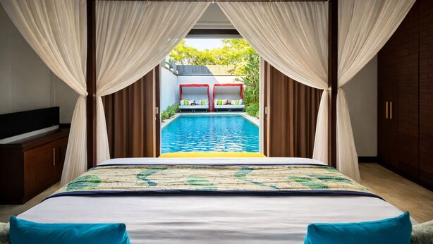 Quarto com cama voltada para uma piscina, cortinas e vista para a área da piscina.
