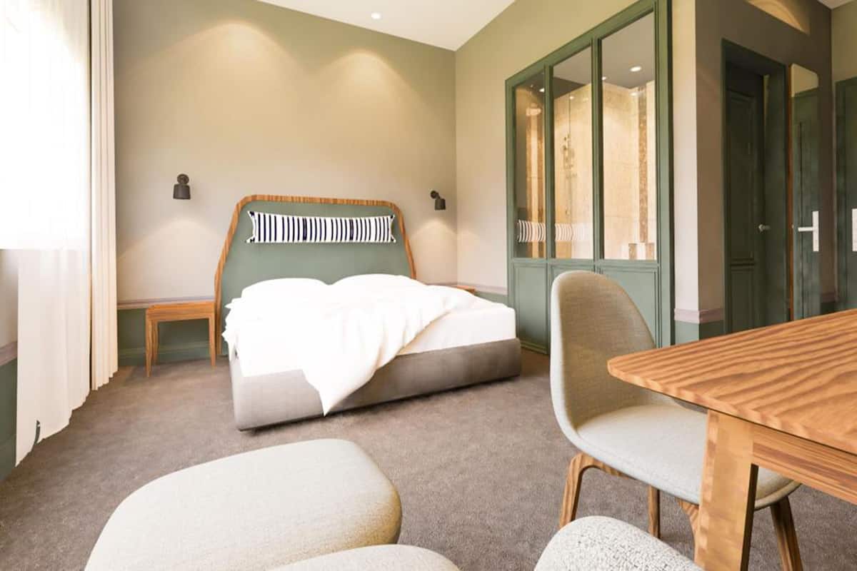 Une chambre d’hôtel avec un lit, une table en bois et une chaise.