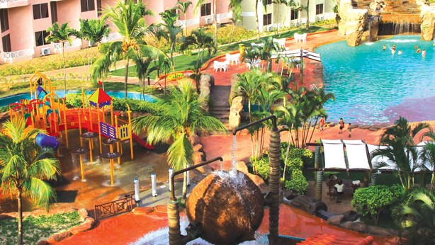 Un complexe hôtelier doté d’un parc aquatique, d’une piscine et offrant une vue sur un bâtiment d’hôtel.